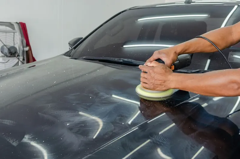 Dual action polisher running across a dark bonnet