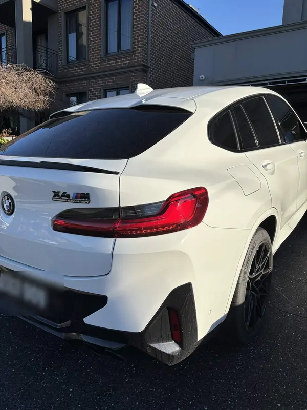 Rear of a white BMW X4 M on a driveway