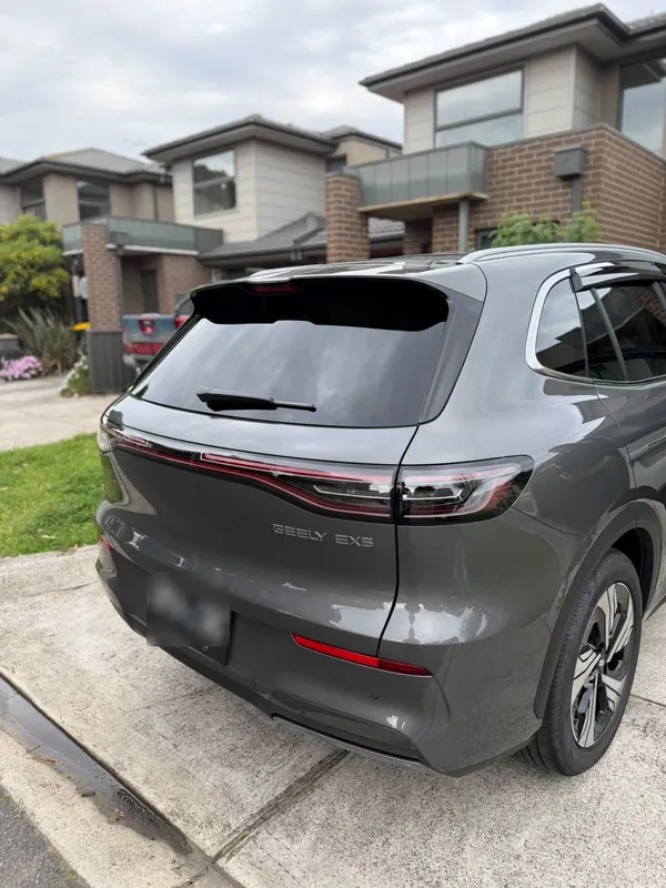 Rear three-quarter view of the Geely EX5 on a driveway