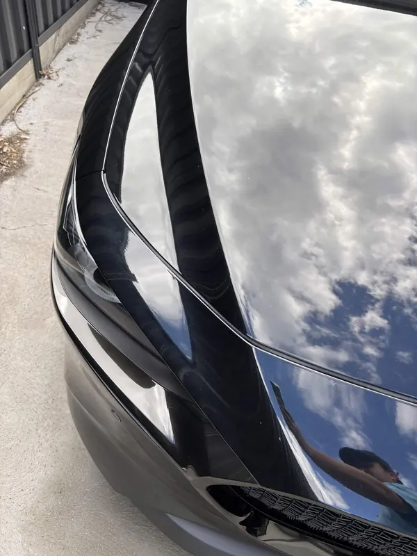 Bonnet edge and headlight of the black Mazda 3