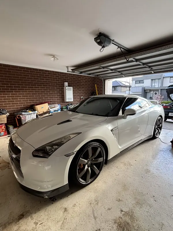 White Nissan GT-R in a garage, front three-quarter view